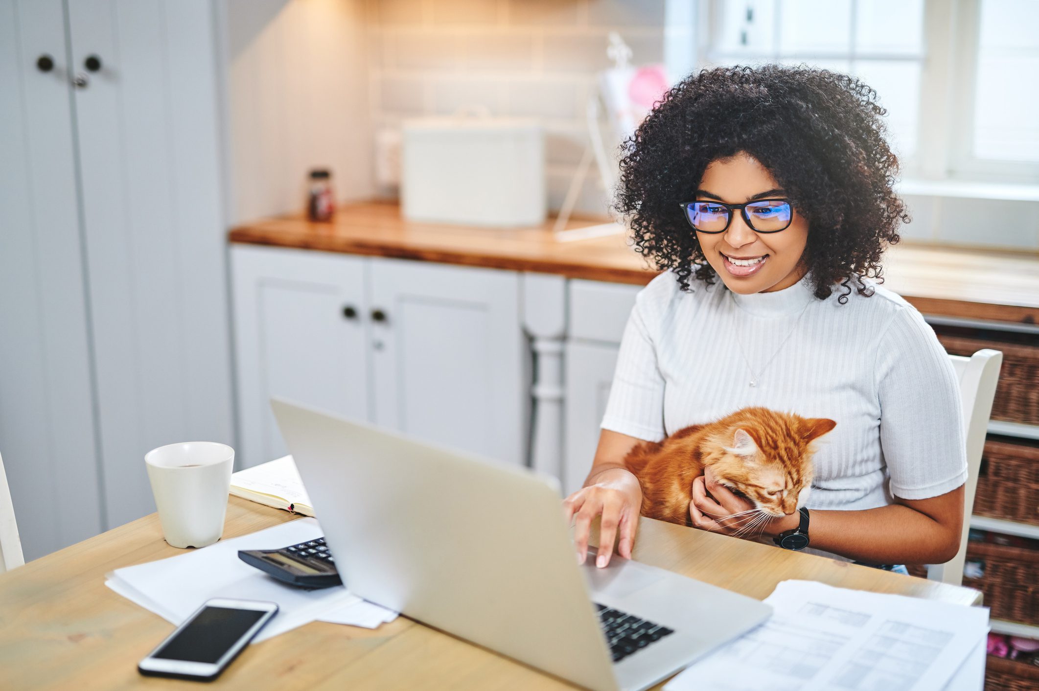 Woman working on laptop with cat