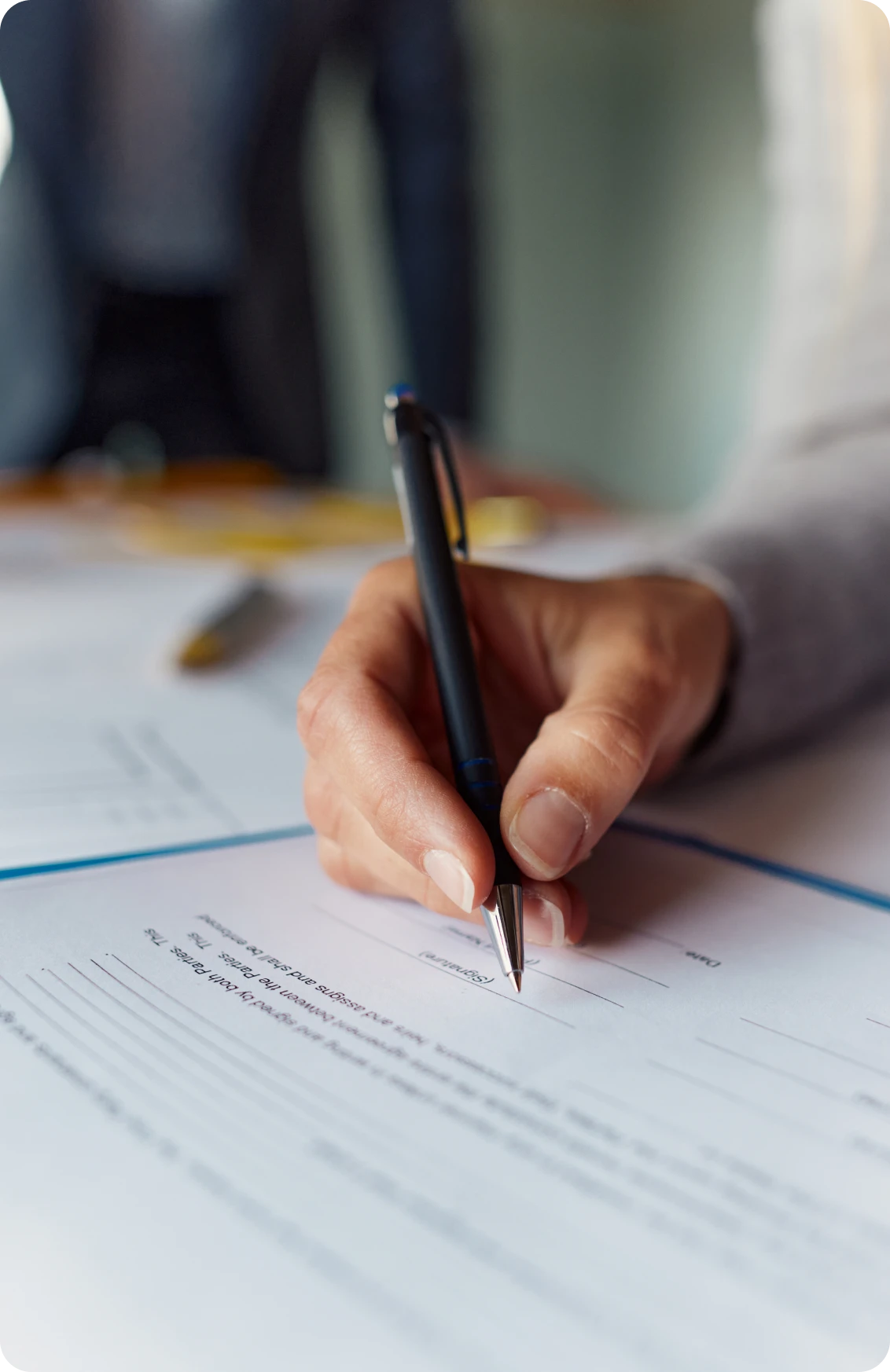 Close-up of hand signing paperwork