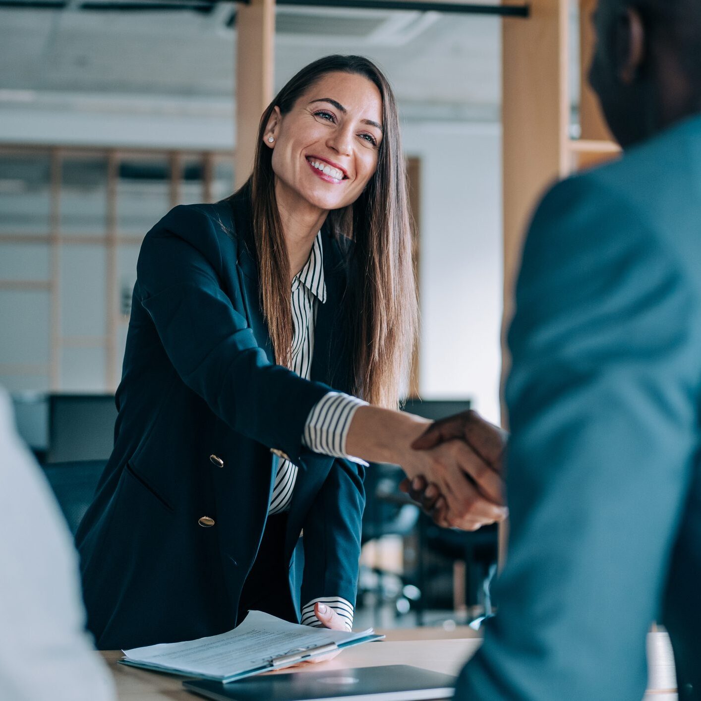 Smiling woman in business attire handshake